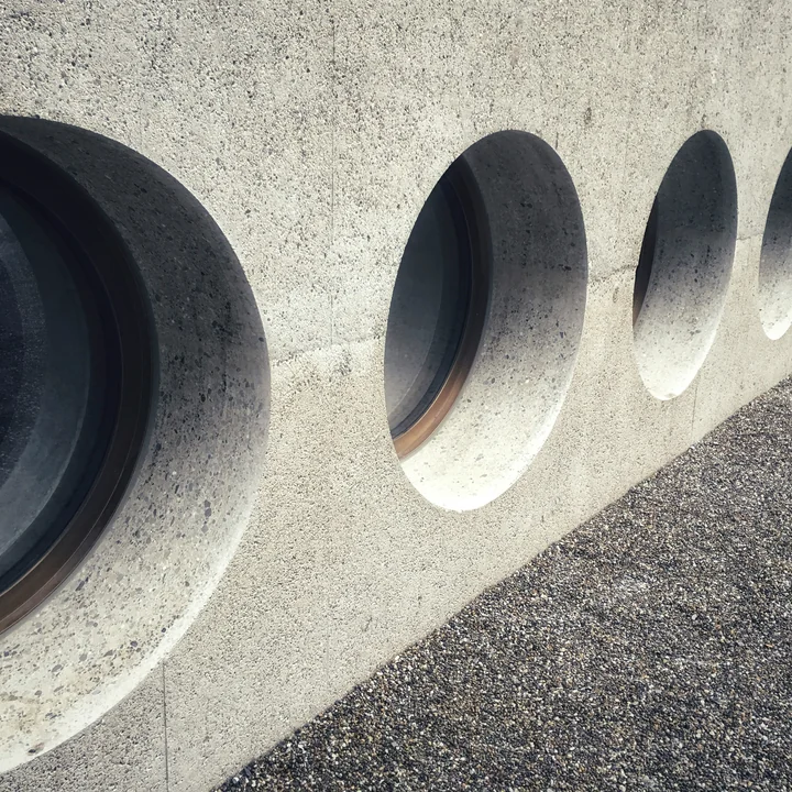 Une rangée de buses traversant un mur béton