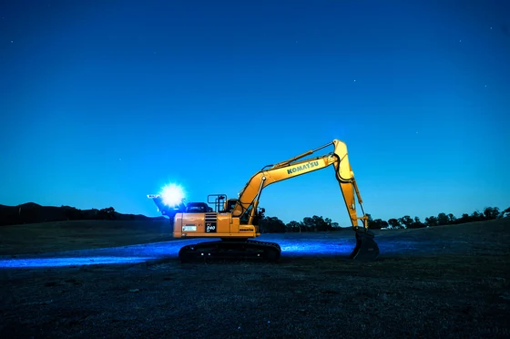Une pelle hydraulique éclairée en pleine nuit sur un terrassement