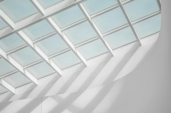 Verrière et ses ombres géométriques sur un mur blanc